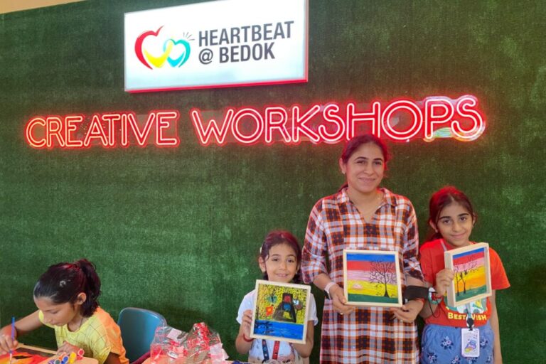 Children and adult proudly displaying their art