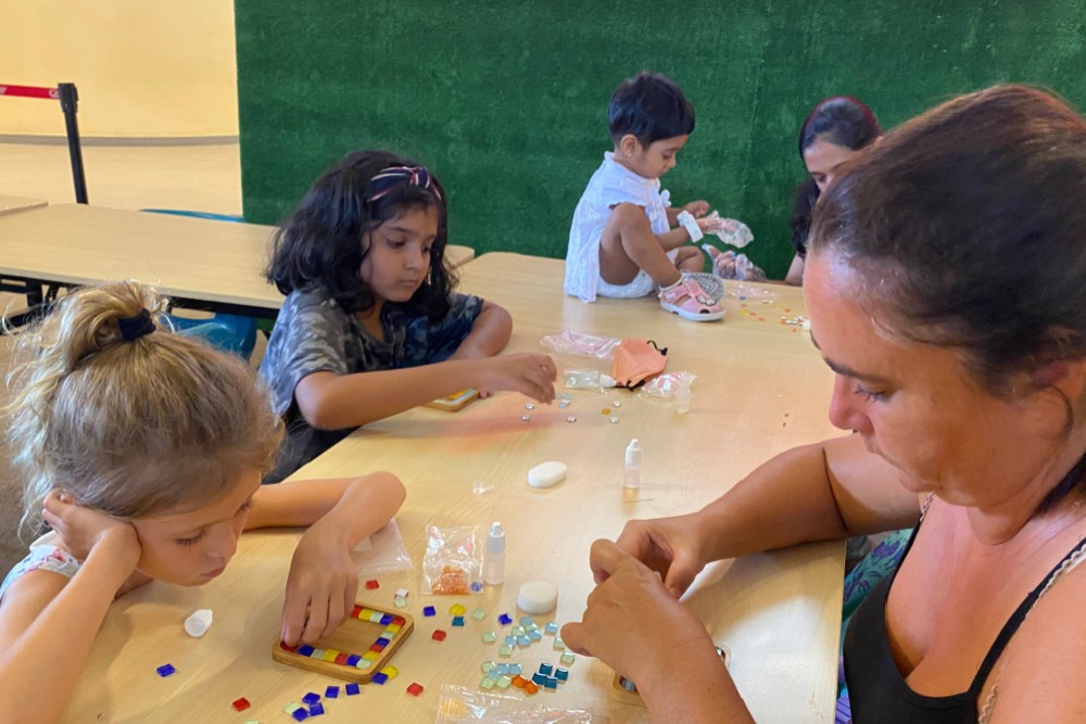 Kids and adults crafting with colorful beads and clay